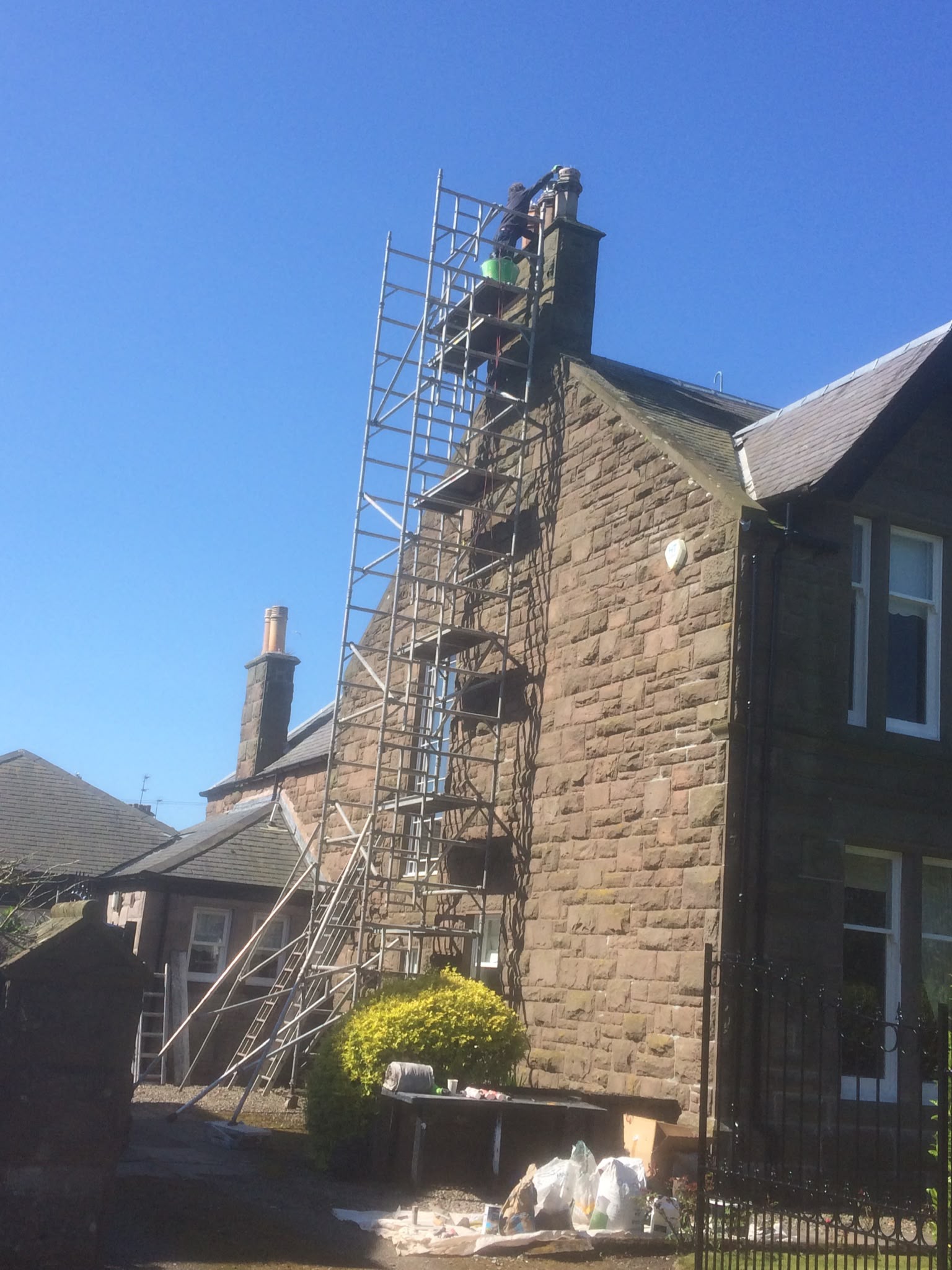 Scaffolding on a sandstone house during exterior work.