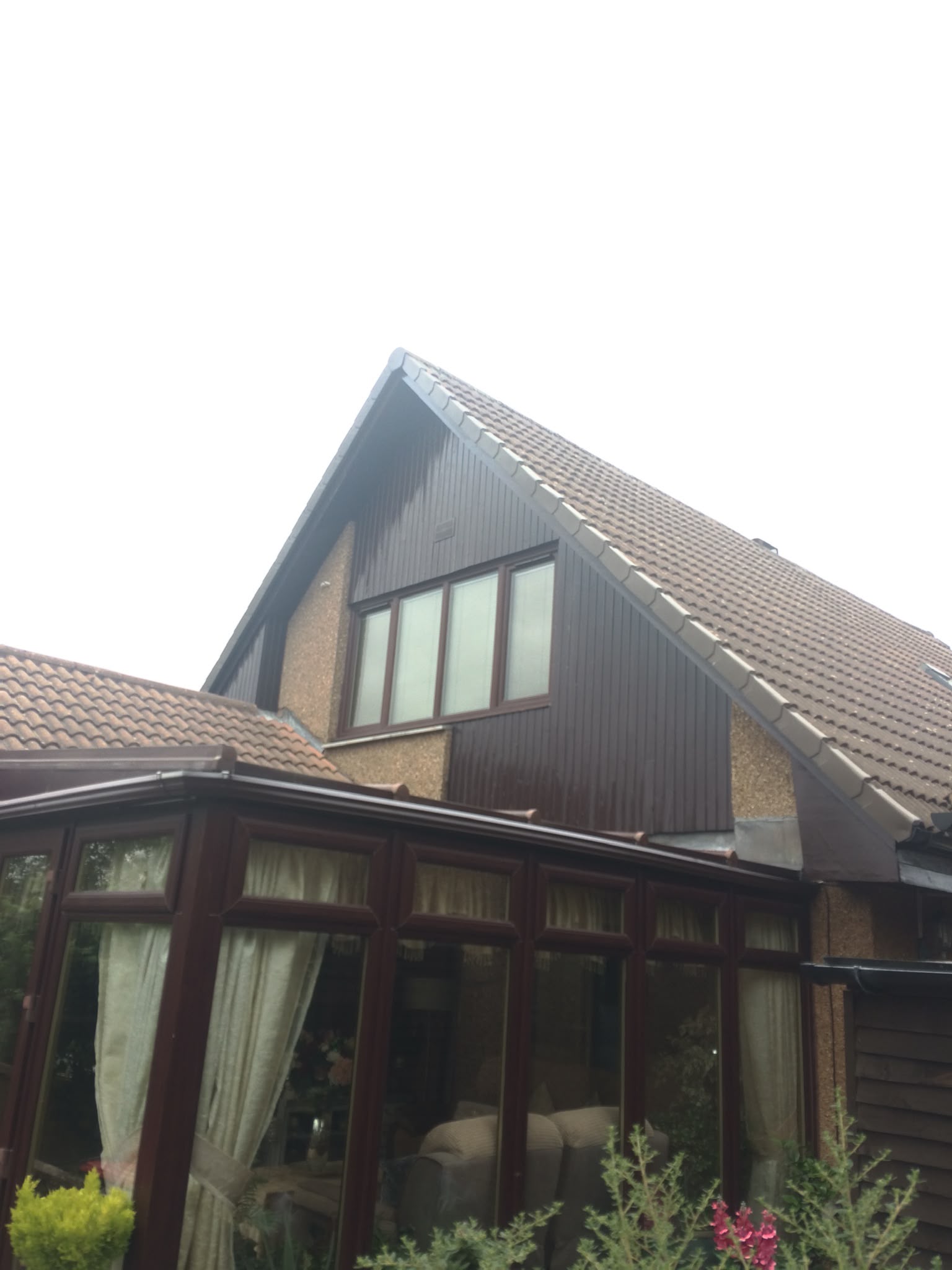 Painted brown timber cladding on a house gable.